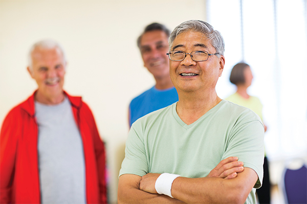 Middle aged man with his arms crossed and smiling